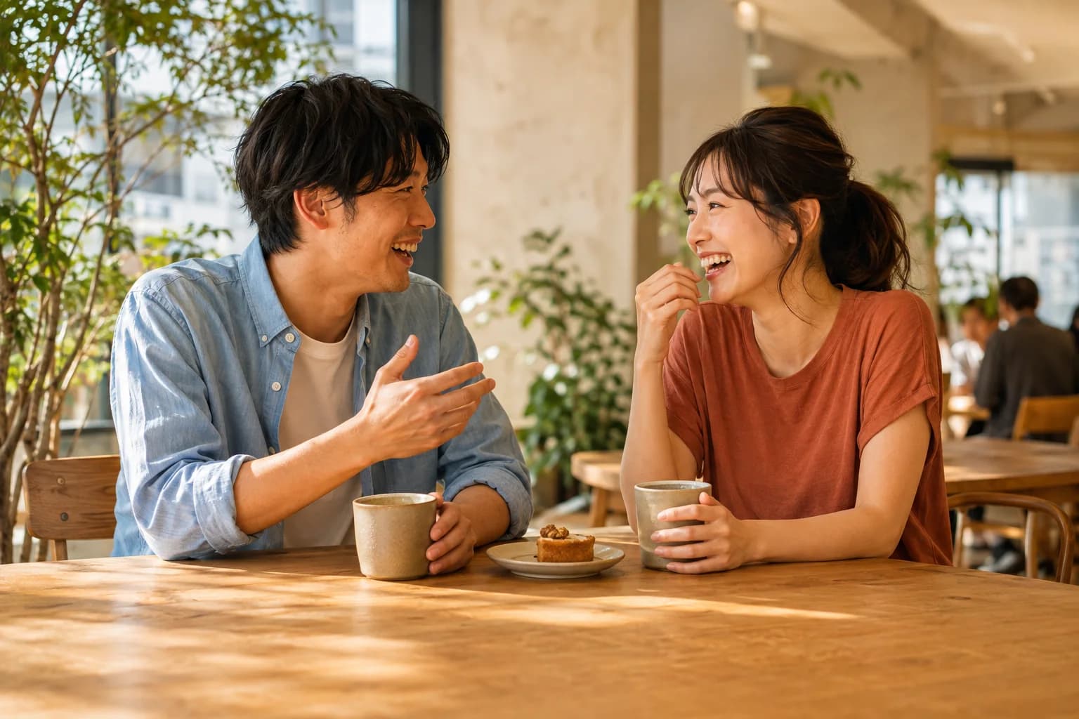 活気のあるカフェで向かい合って笑う男女