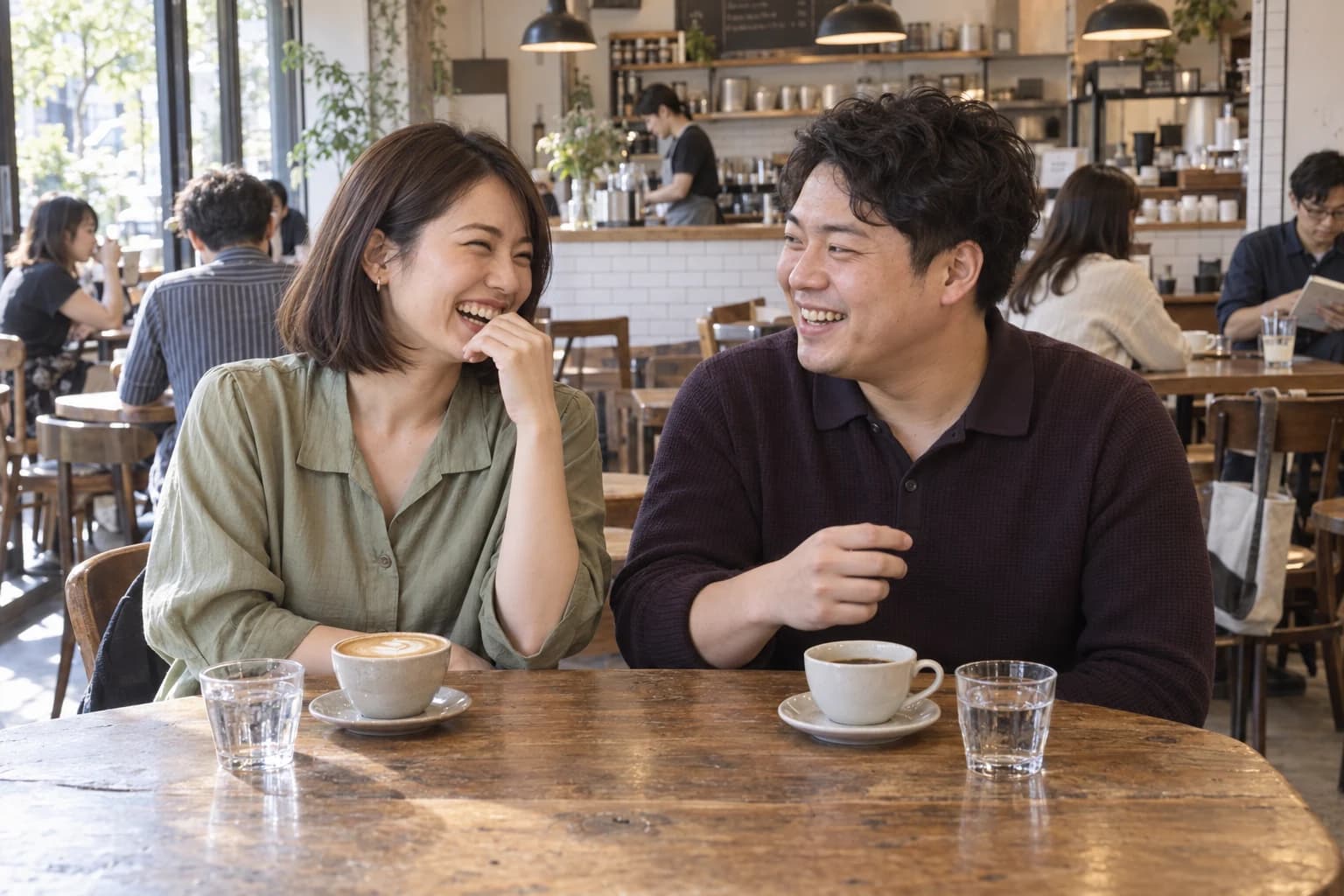 カフェで笑顔で会話を楽しむ男女のイメージ