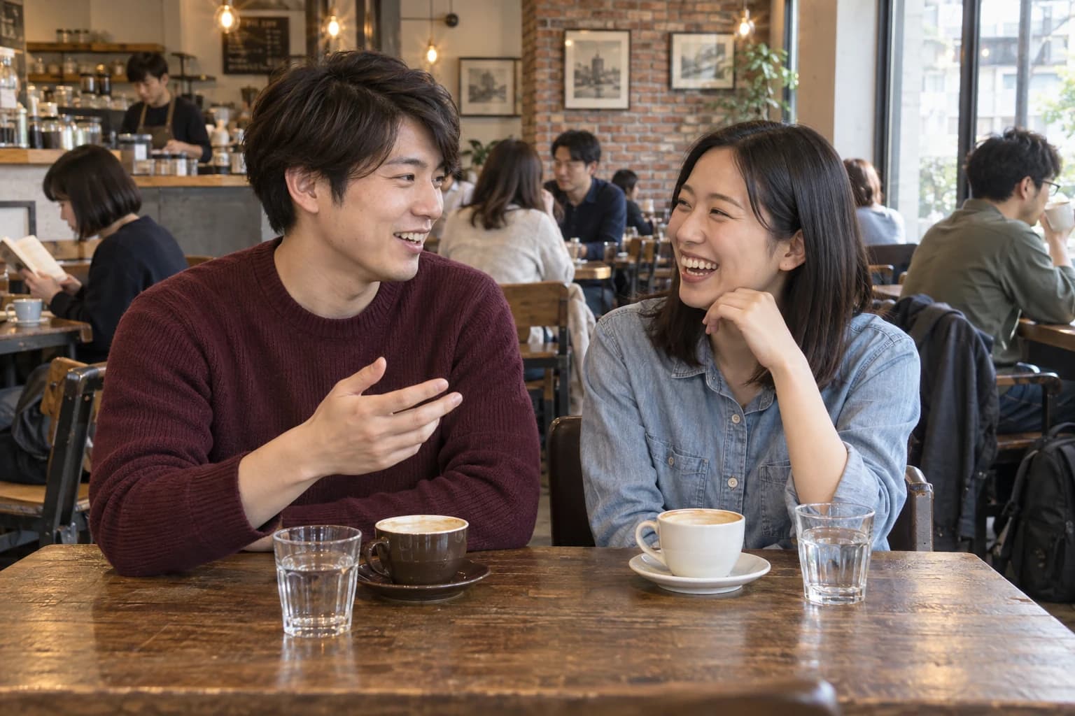 カフェで笑顔で会話を楽しむ男女のイメージ